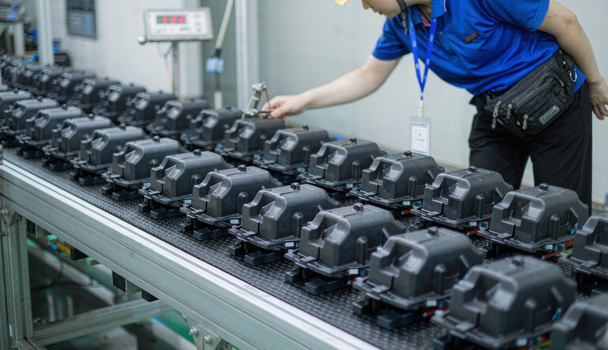Production run of molded plastic housings checked by an operator during high volume injection molding
